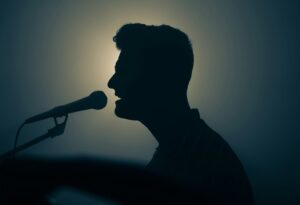 profile of man singing into a microphone